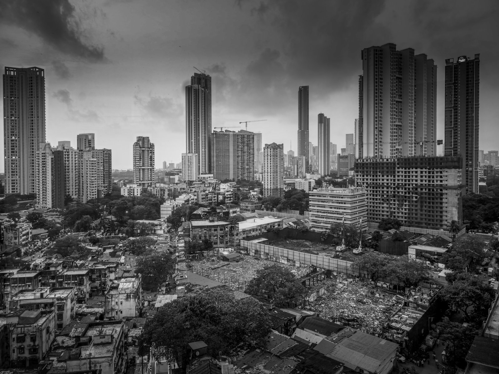 Glass high-rise towers rising directly behind low, older rooftops.