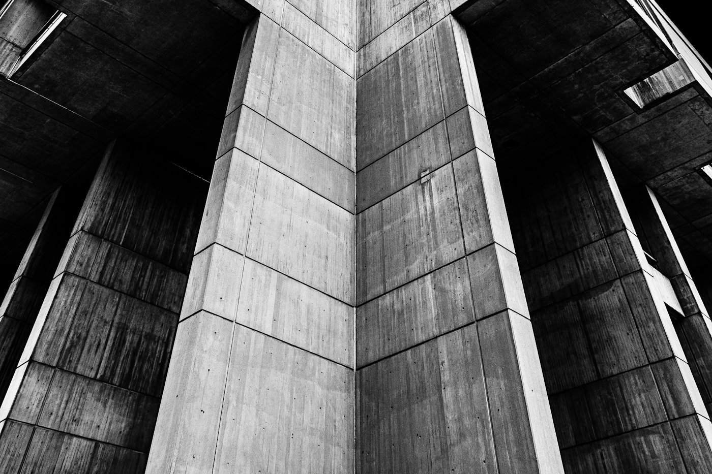 A grey concrete apartment block photographed in black and white.