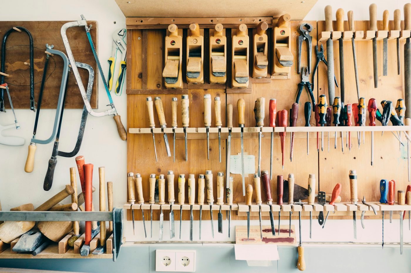 Hand tools arranged on a workshop rack.