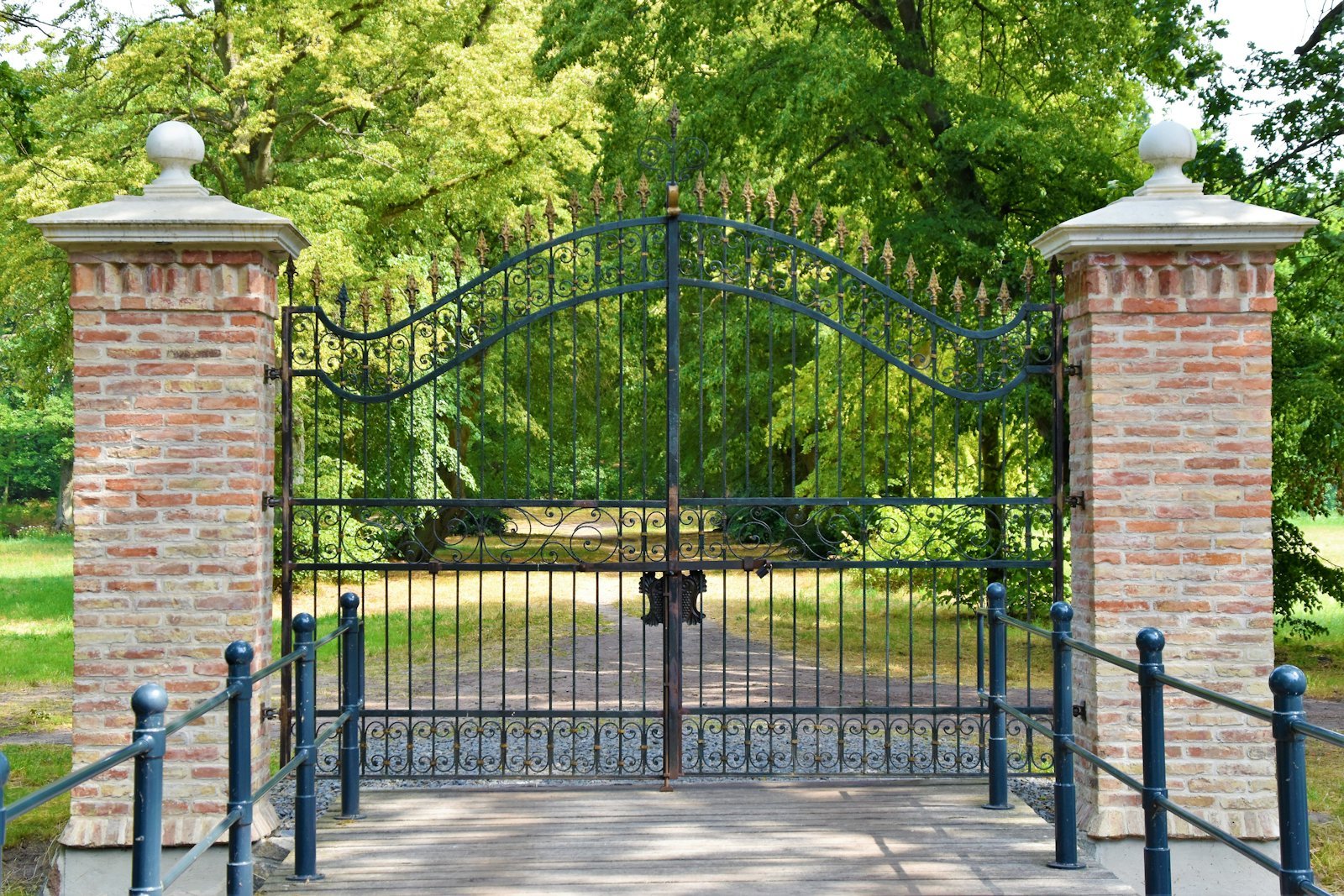 A tall iron gate closed across a private driveway.